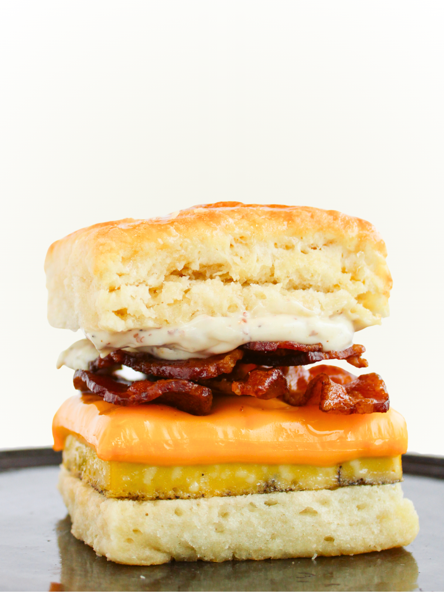 Biscuit sandwich with bacon and cheese on a white background