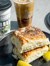 Stack of lemon poppyseed biscuits with a cup of iced coffee on a table